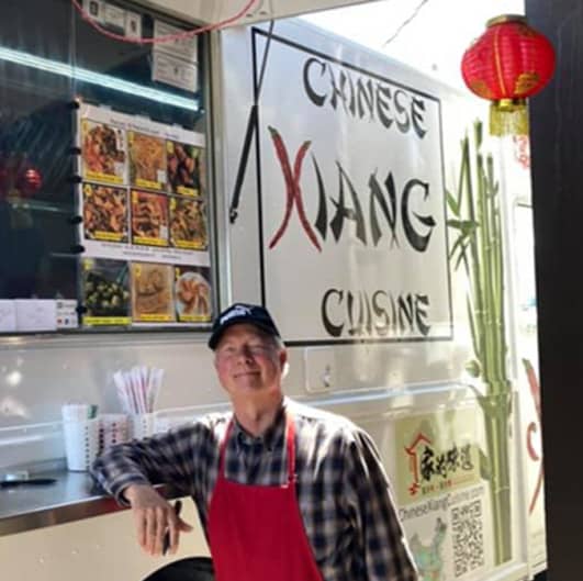 A photo of David in front of the Chinese Xiang Food Truck